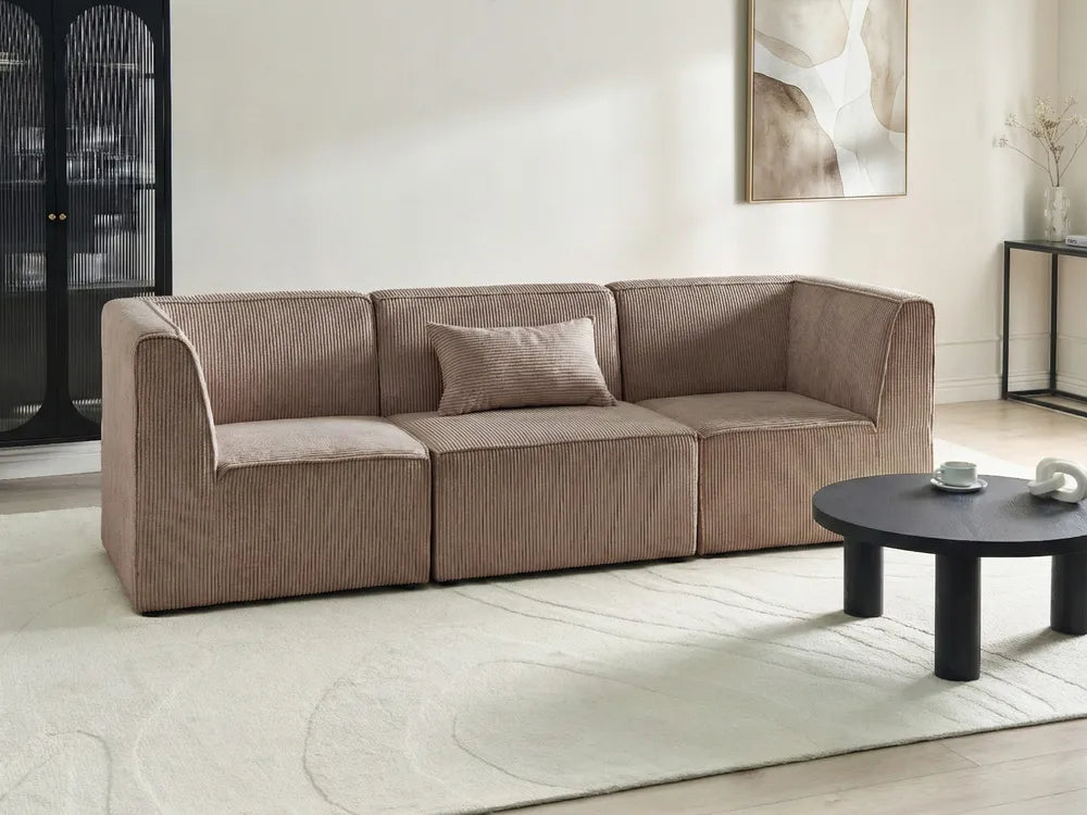 Beige sofa in a modern living room with a coffee table and abstract art on the wall.
