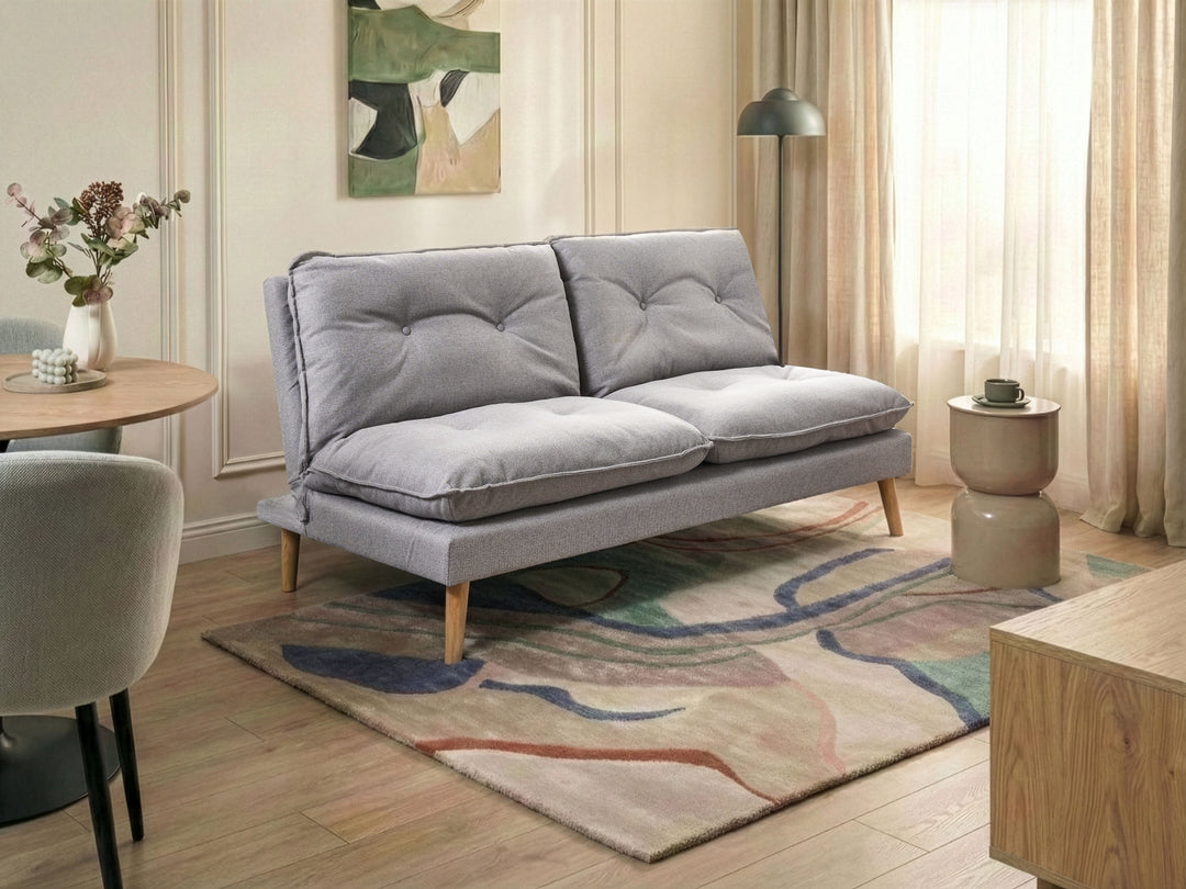Gray sofa in a living room with a rug, table, and decorative elements.