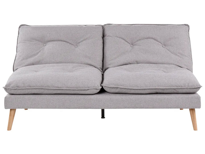 A light gray fabric futon sofa with two tufted back cushions, two thick seat cushions, and tapered light wood legs, shown against a plain white background.