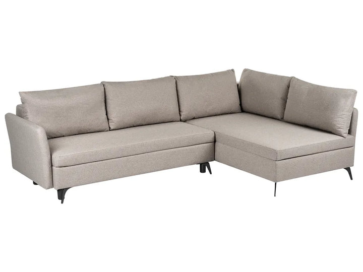 A light beige upholstered sectional sofa with a right-facing chaise lounge and four matching back cushions, shown on a plain white background.