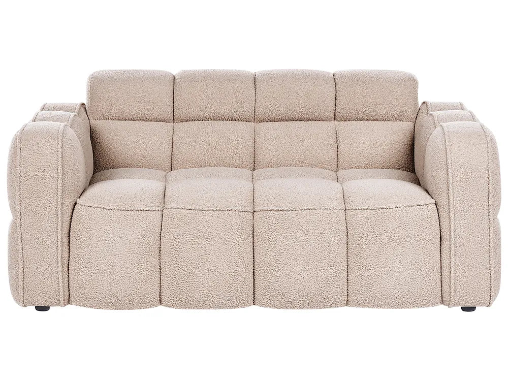 A modern three-seater sofa with a chunky, tufted block design and textured boucle-style upholstery in a light beige color, shown against a plain white background.