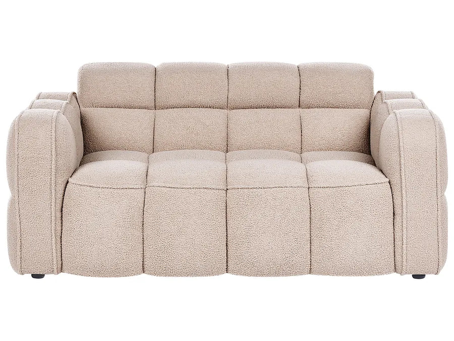 A modern three-seater sofa with a chunky, tufted block design and textured boucle-style upholstery in a light beige color, shown against a plain white background.