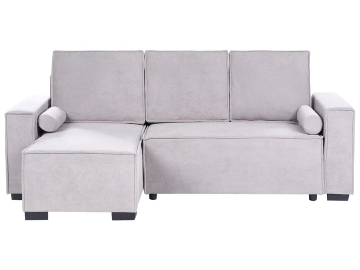 A light gray upholstered sectional sofa with a left-facing chaise lounge, three back cushions, cylindrical armrests, and small dark feet, shown on a plain white background.