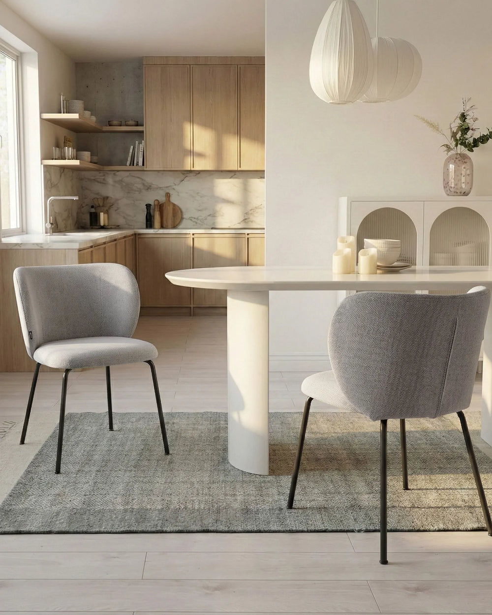 Modern kitchen with a dining area featuring a white table and gray chairs.