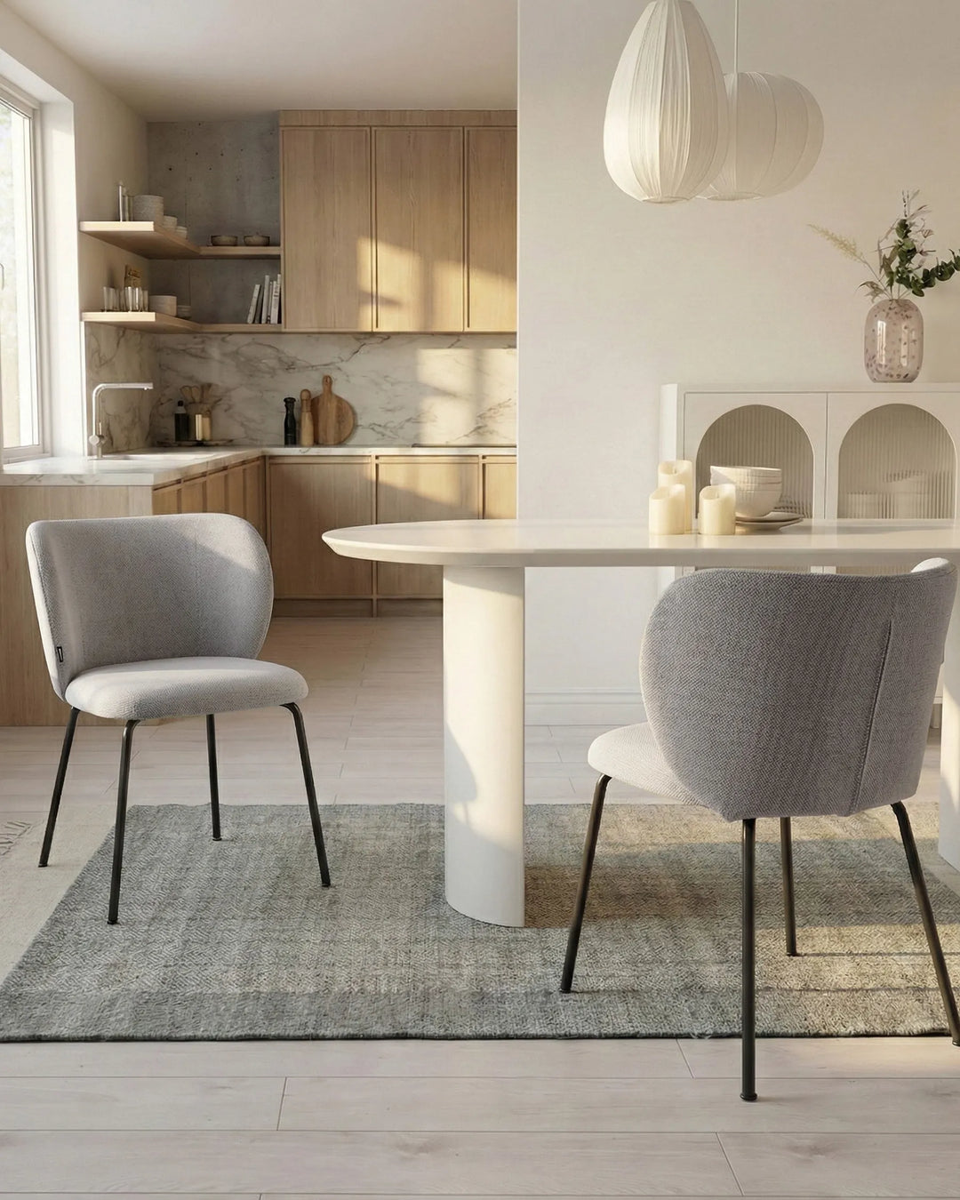 Modern kitchen with a dining area featuring a white table and gray chairs.