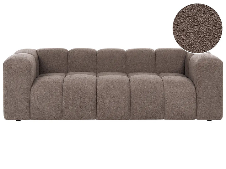 A modern low-profile sofa with a tufted, segmented backrest and chunky armrests in a textured taupe fabric, featuring a circular fabric close-up inset in the top right corner.
