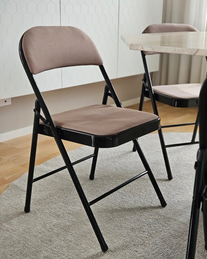 Brown folding chair with black frame on a gray rug