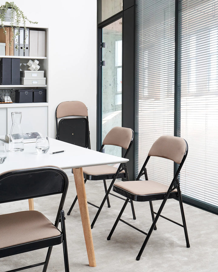 Modern office setting with a white table and beige chairs.