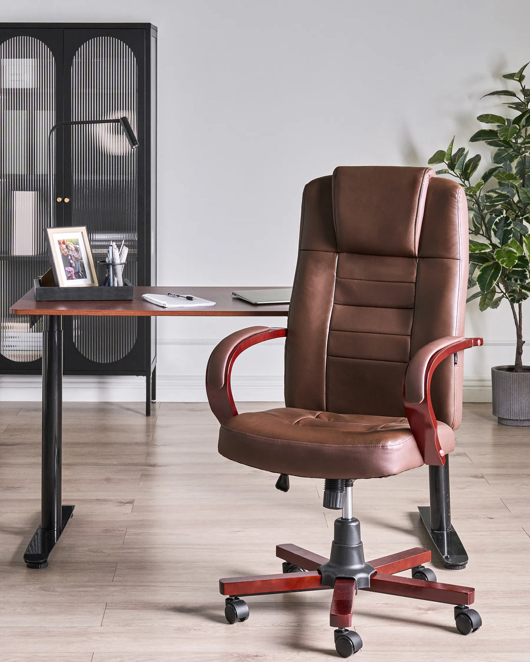 Brown office chair in a home office setting with a desk and decor.