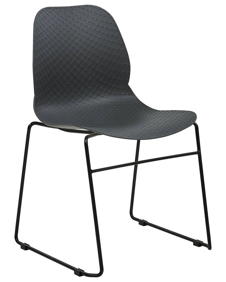 A modern black chair with a textured, honeycomb-patterned seat and a slim metal sled base, shown against a plain white background.
