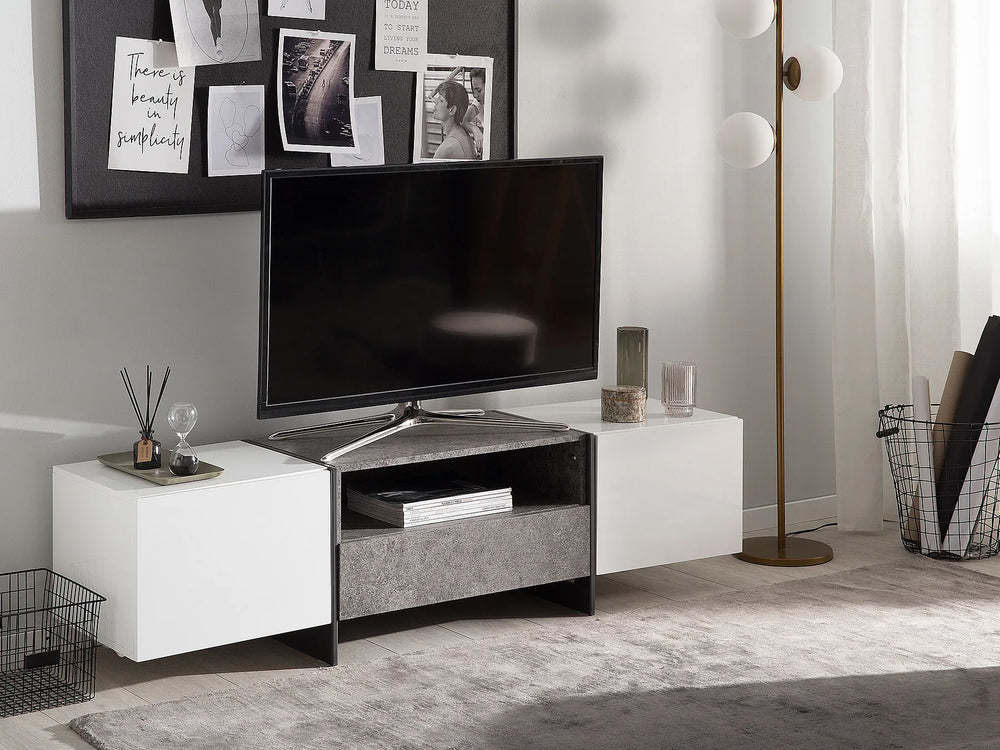 A modern TV stand and media console in a styled living room setting. The console features a white high-gloss side cabinet, a textured gray center drawer, and a black metal frame holding a flat-screen television.