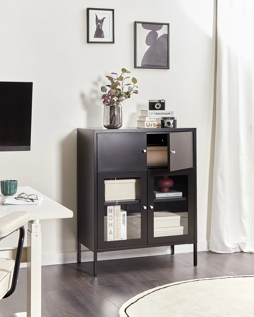 Dark wooden cabinet with glass doors in a room with a TV and decor items.