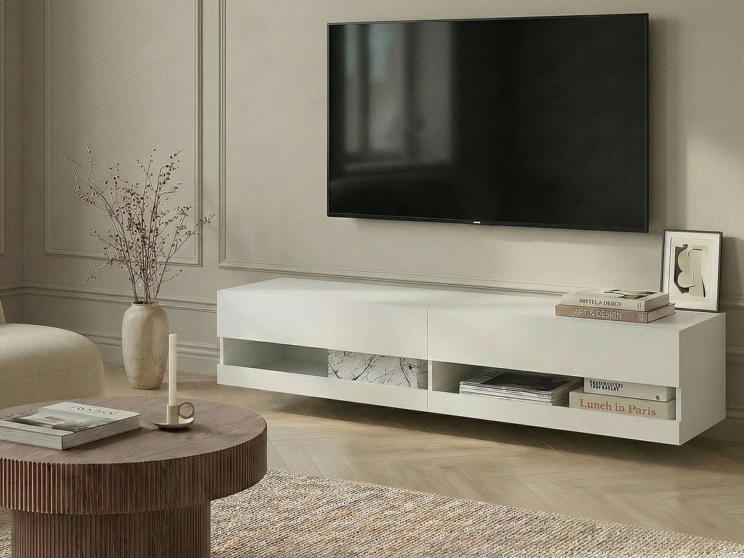 A modern white floating TV stand in a living room setting, shown below a wall-mounted flat-screen television. The stand features open shelving and marble-patterned drawer inserts.