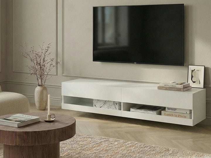 A modern white floating TV stand in a living room setting, shown below a wall-mounted flat-screen television. The stand features open shelving and marble-patterned drawer inserts.