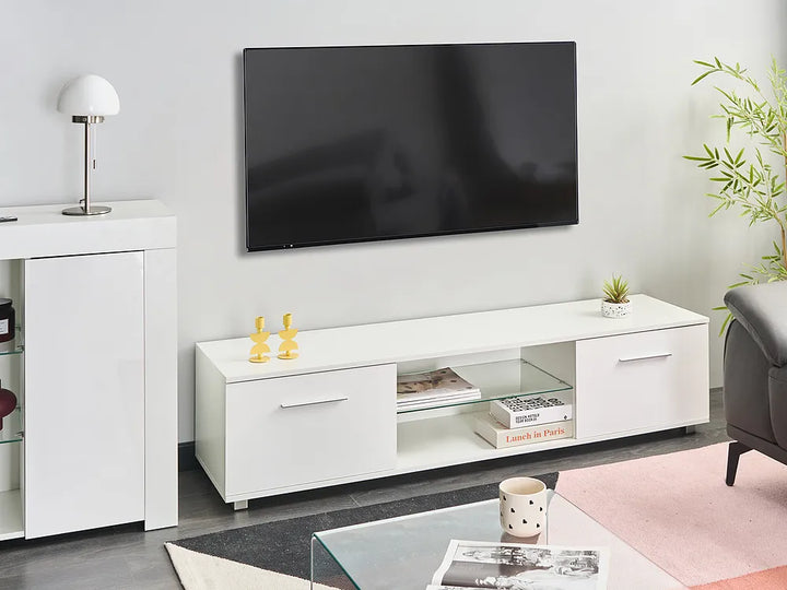 A modern white TV stand console with open shelving and two drawers, styled in a living room setting below a wall-mounted flat-screen television.