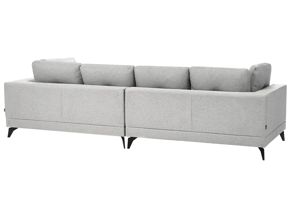 A light gray fabric sectional sofa with a low back and tapered black legs, shown from a three-quarters angle against a plain white background.