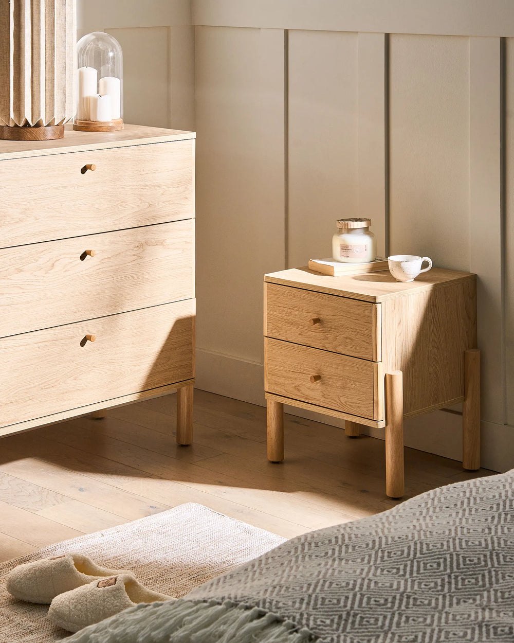 Wooden dresser and nightstand in a bedroom setting with soft lighting.