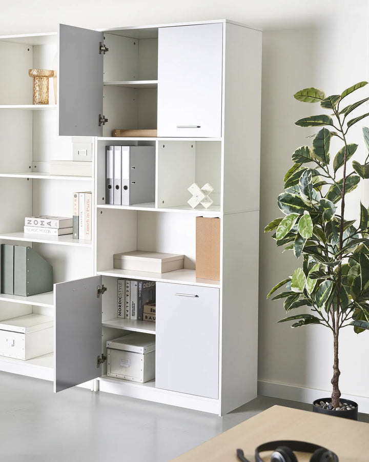 White storage cabinet with open doors in a room with a plant and desk.