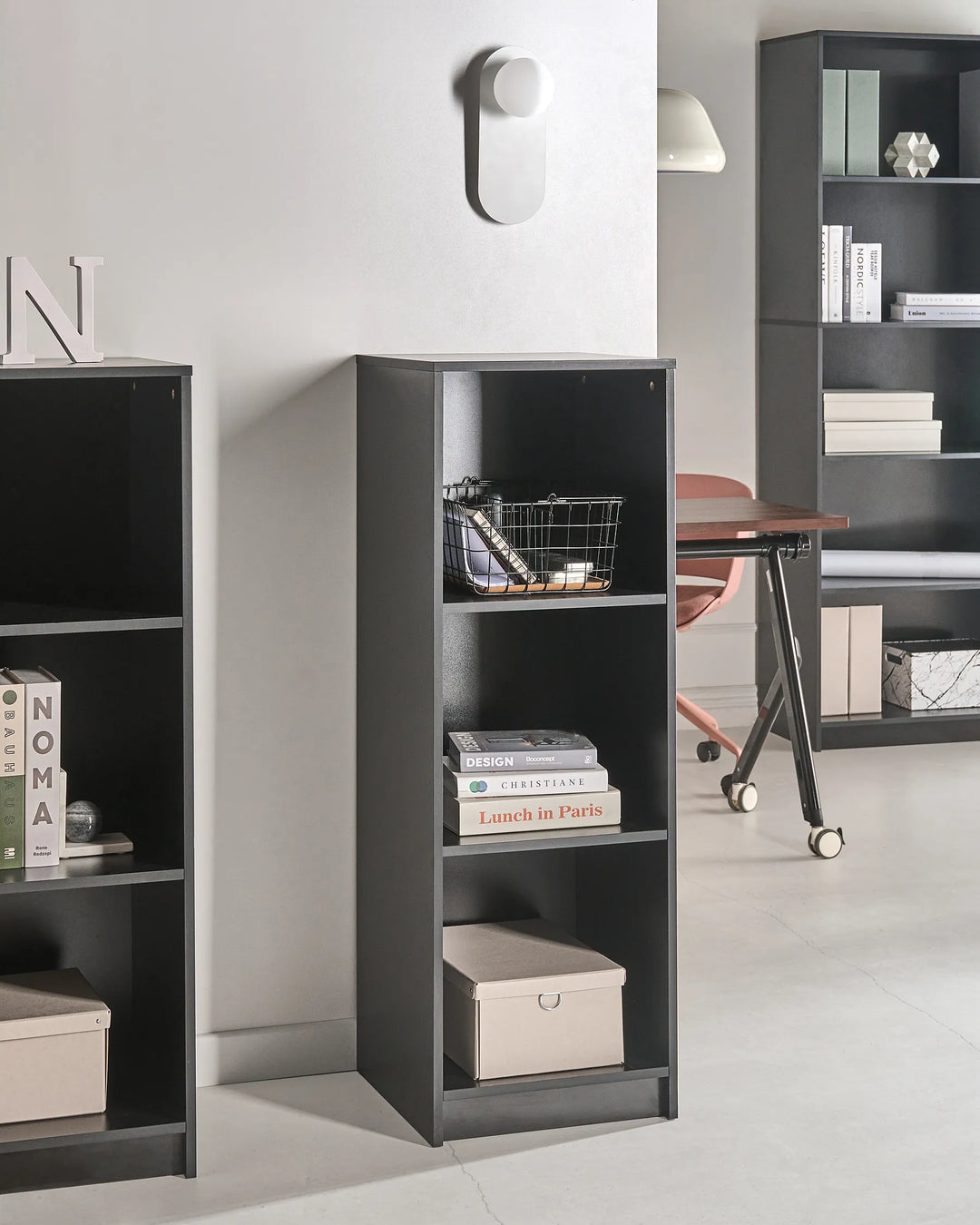 Black bookshelf with books and decorative items in a room setting
