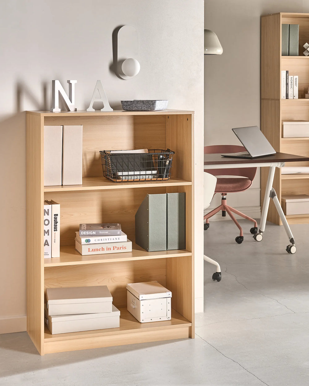 Wooden bookshelf with books and decor in a home office setting