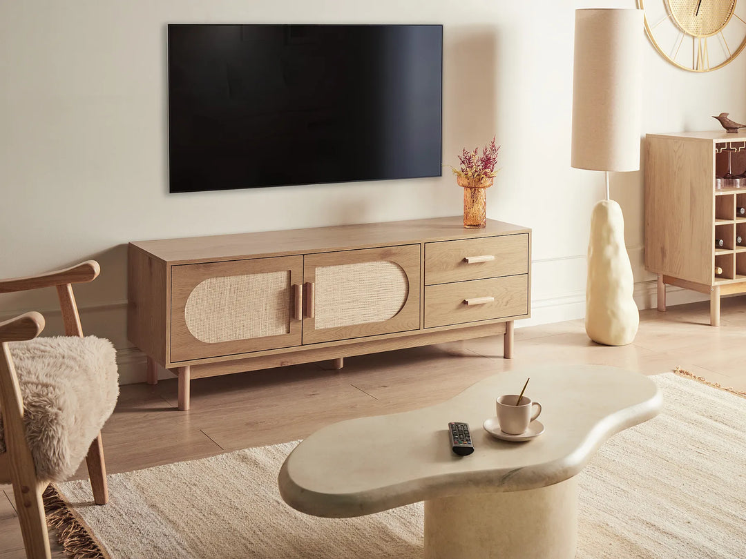 Modern living room with wooden TV stand, coffee table, and decorative items.