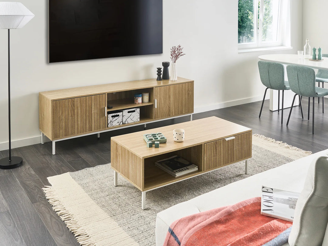 Modern living room with wooden TV stand and coffee table, dining area in the background.