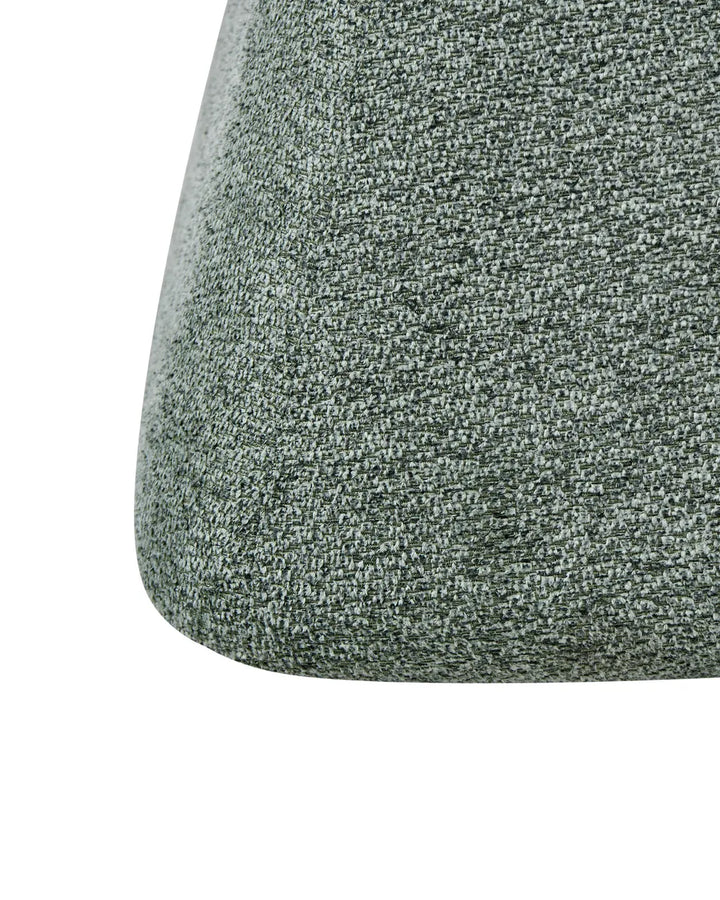 Close-up of a textured fabric upholstered curved surface in a heathered gray-green color, shown against a plain white background.