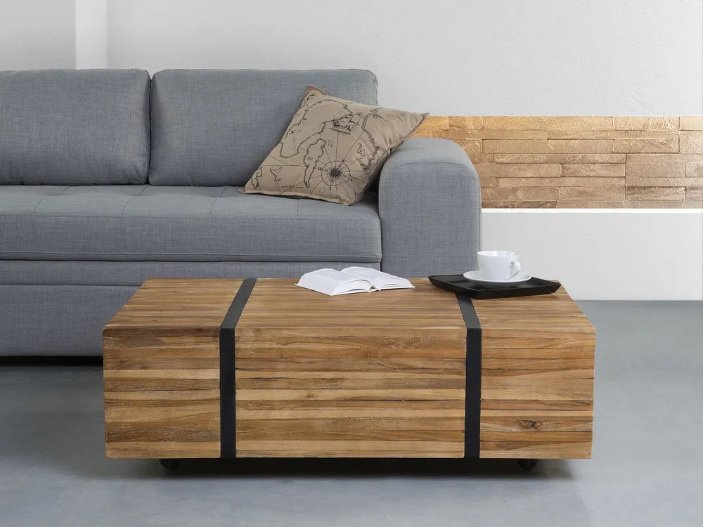 Wooden coffee table with black straps in front of a gray sofa.