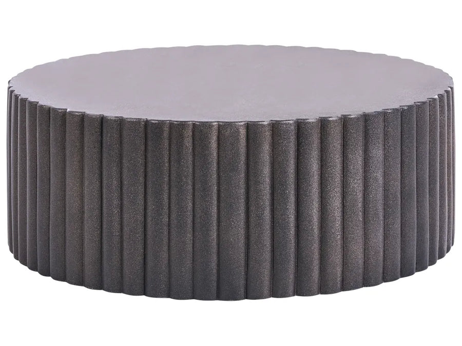 Round ottoman with textured surface and gray cushion on a white background