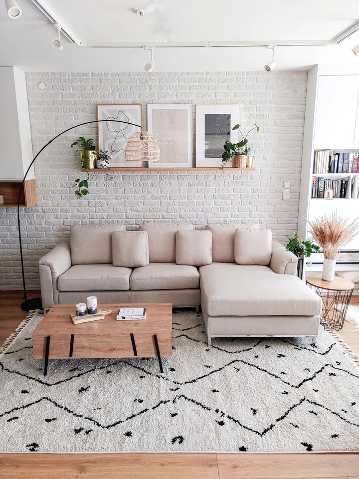 Modern living room with a beige sectional sofa, wooden coffee table, and decorative elements.