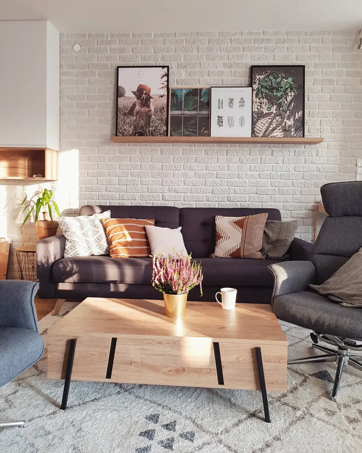 Modern living room with a gray sofa, wooden coffee table, and decorative elements.