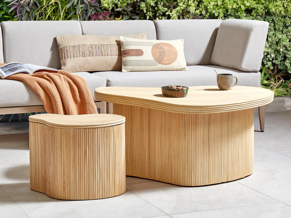 Outdoor seating area with a light gray sofa, wooden coffee table, and side table.