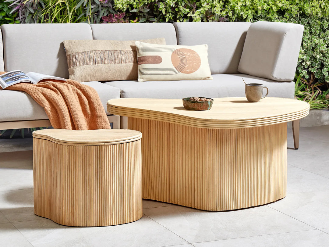 Outdoor seating area with a light gray sofa, wooden coffee table, and side table.