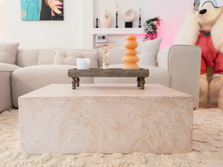 Living room with a stone coffee table, gray sofa, and decorative items.