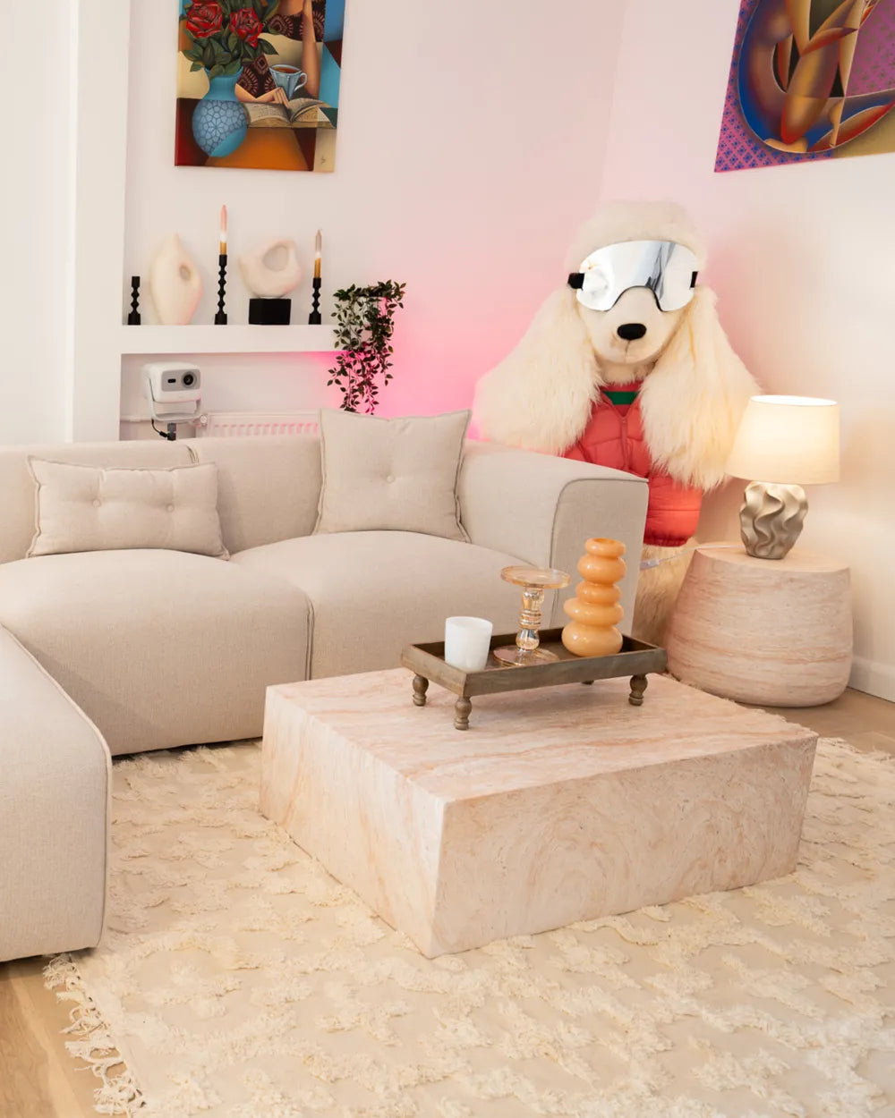 Living room with beige sofa, marble coffee table, and decorative items.