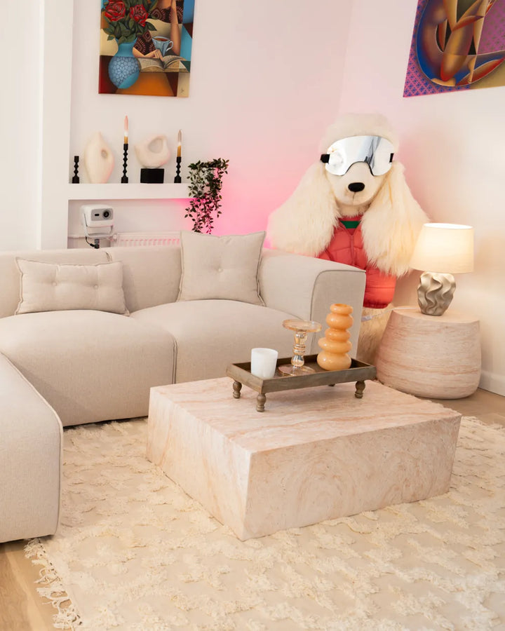 Living room with beige sofa, marble coffee table, and decorative items.