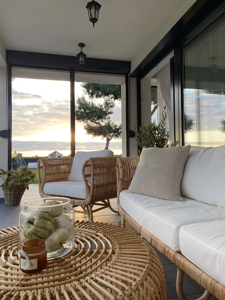Outdoor patio with wicker furniture and a view of the ocean.