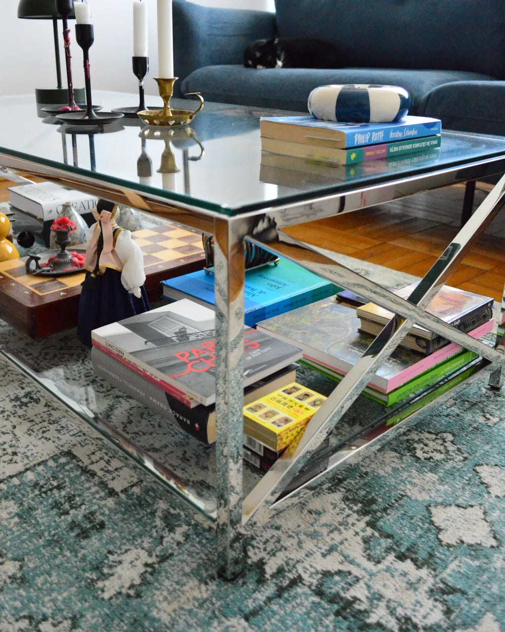 Glass coffee table with books and decorative items in a living room setting