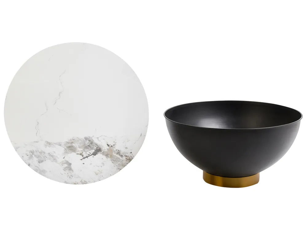 Black bowl with gold base next to a marble sphere on a white background