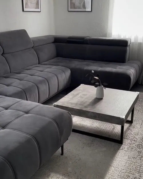 Gray sectional sofa in a living room with a coffee table and decorative items.