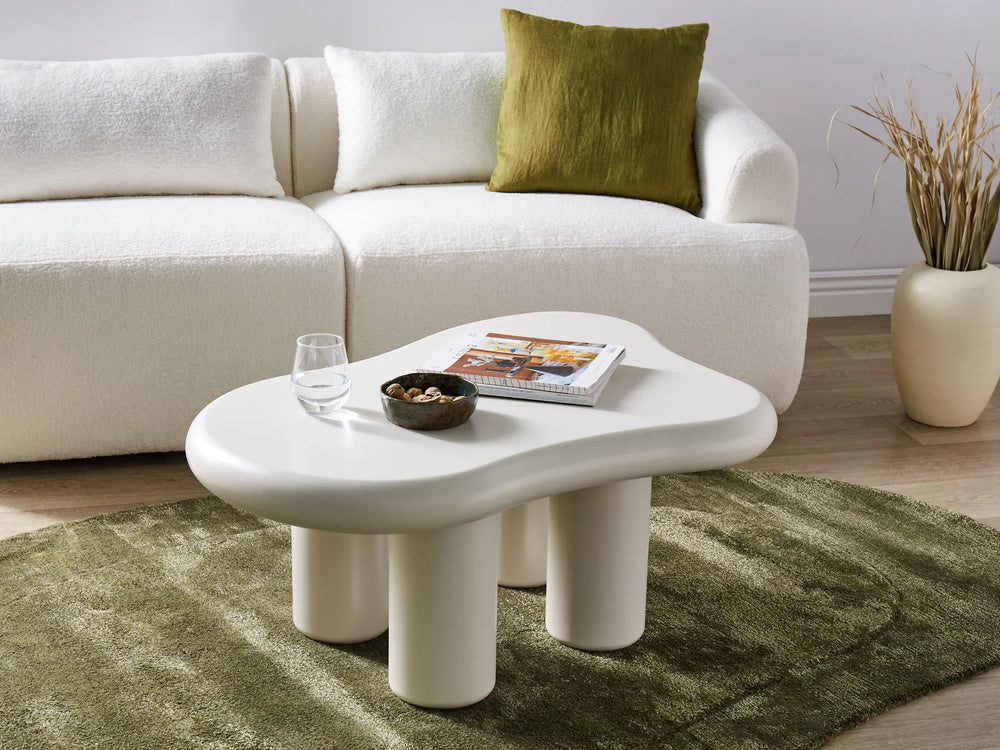 Modern living room with a white sofa, coffee table, and decorative items.