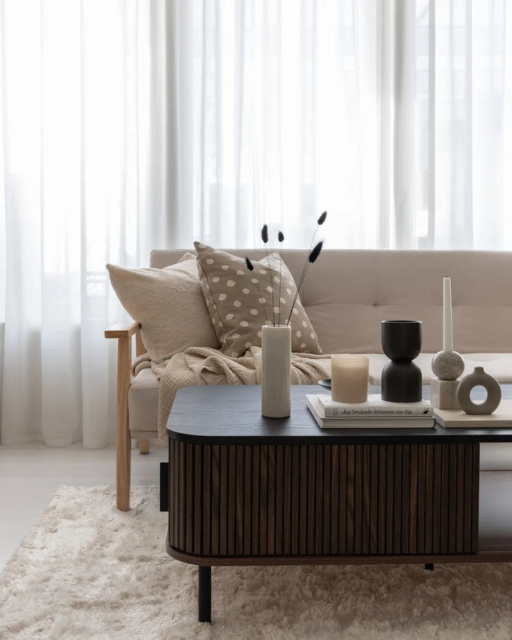 Modern living room with a sofa, coffee table, and decorative items.