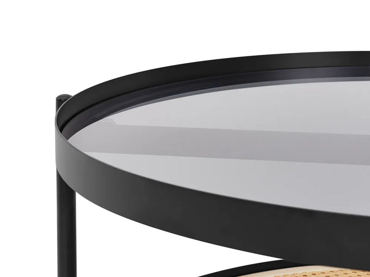 Round black metal table with glass top on a white background
