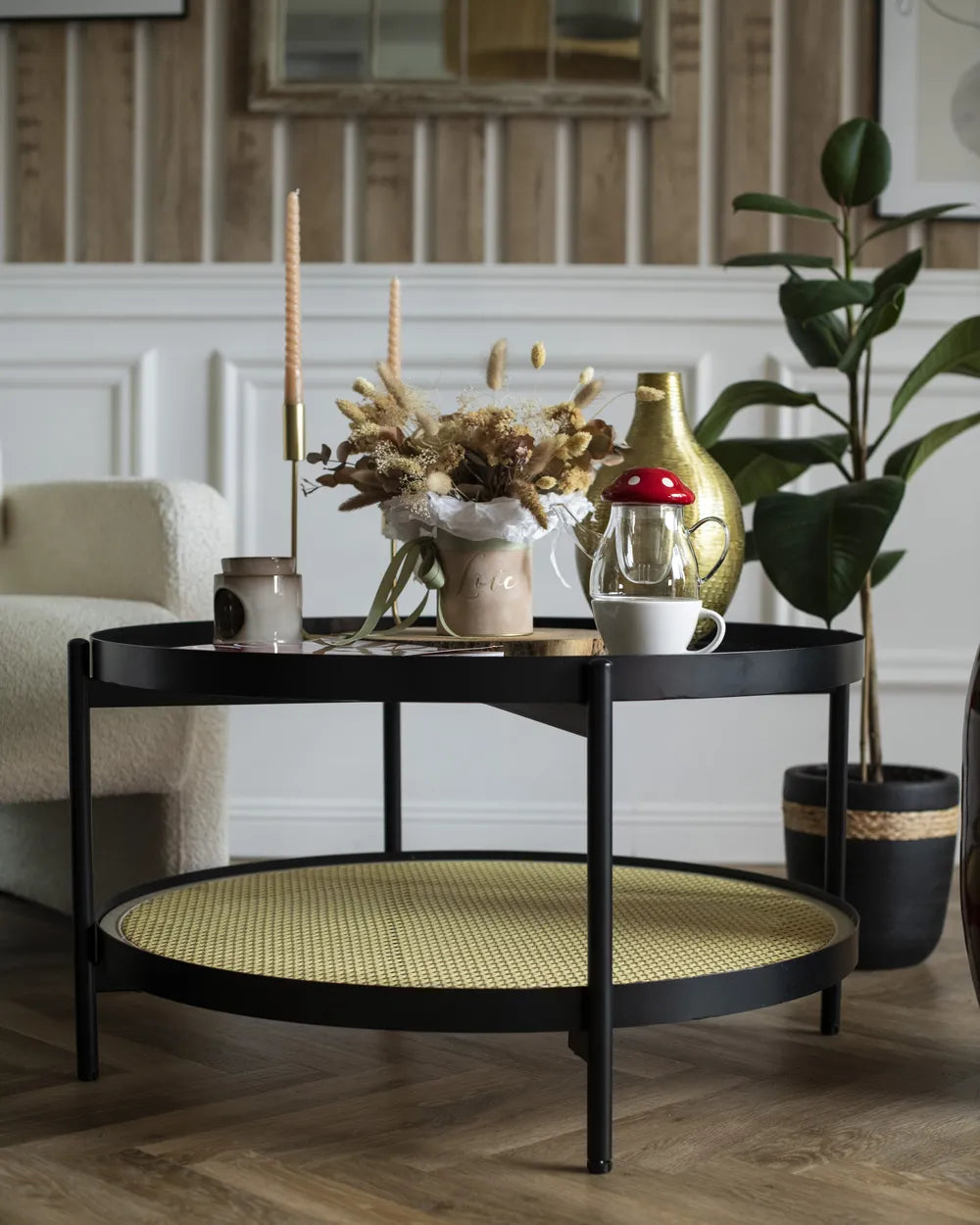 Black metal coffee table with decorative items in a living room setting