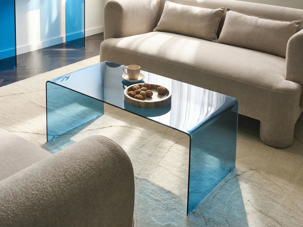 Modern living room with a glass coffee table and beige sofa.
