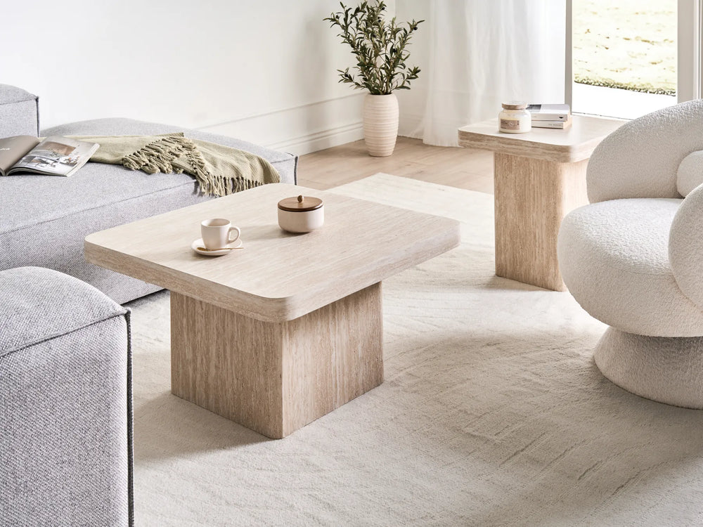 Modern living room with a light wood coffee table, gray sofa, and decorative items.