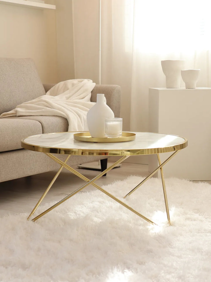 Modern coffee table with gold legs in a living room setting