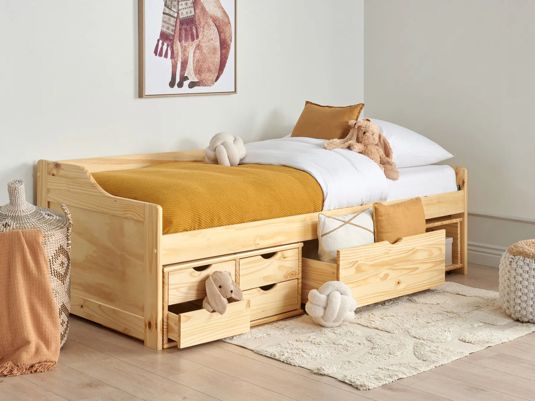 Wooden children's bed with storage drawers in a room setting.