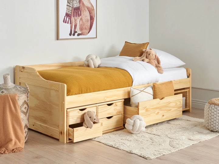 Wooden children's bed with storage drawers in a room setting.