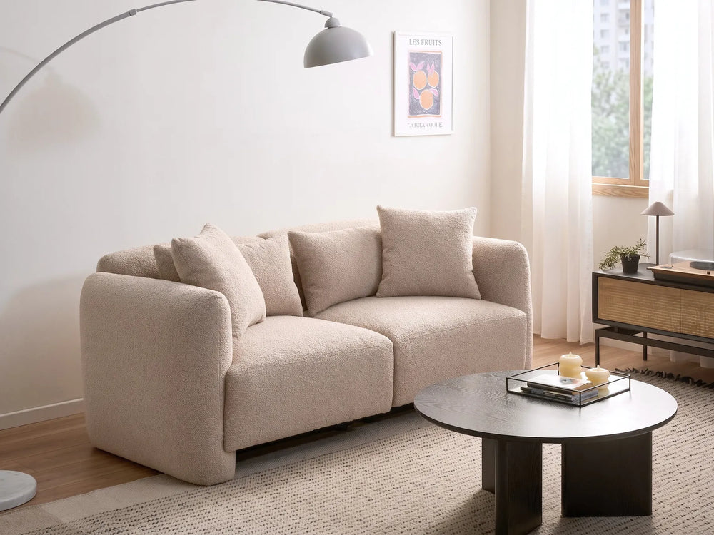Beige sofa in a living room with a coffee table and decor items.